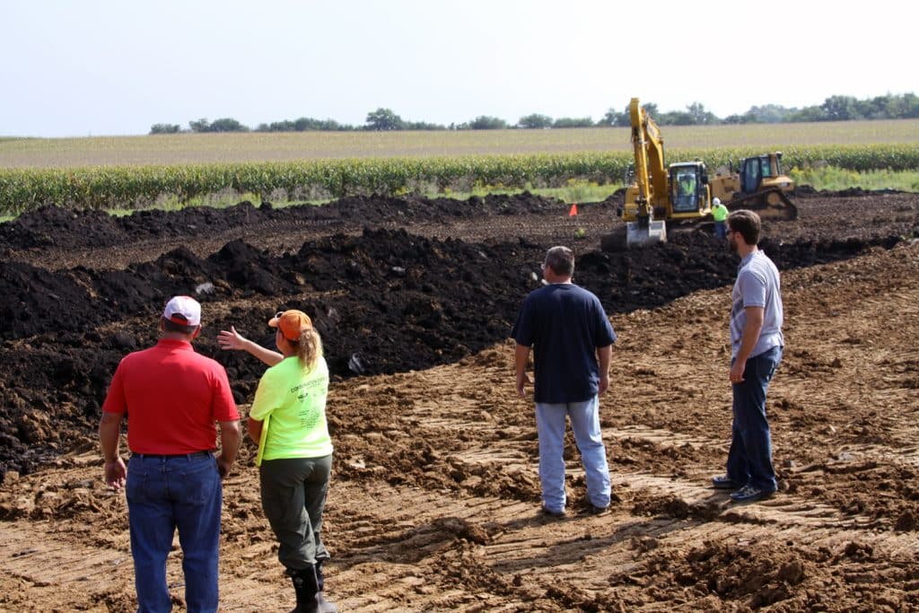 Jill overseeing wetland construction with farm owners