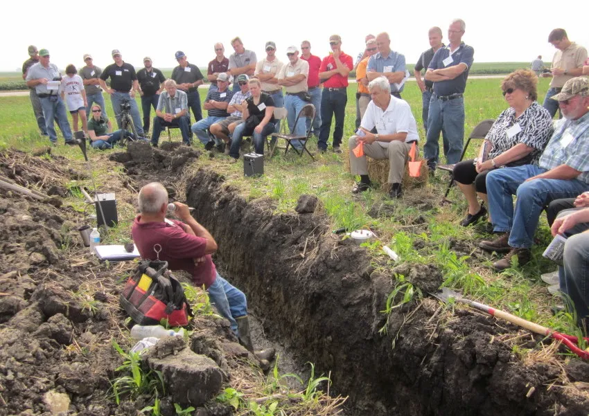 Here, a crowd gathers around a soil pit to learn from Roger Windhorn, Illinois NRCS.