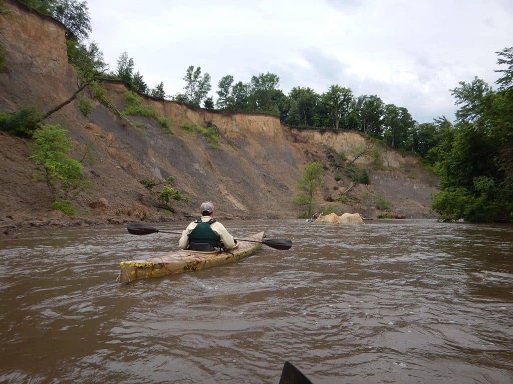 person kayaking on river